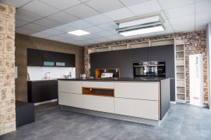 Moderne Kücheninsel mit schwarzen und weißen Fronten sowie eingebauten Bosch-Geräten