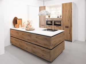 Moderne Echtholzküche mit Kücheninsel, weißen Arbeitsplatten und integriertem Backofen